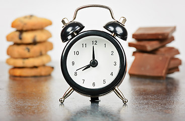 Image showing Black alarm clock with sweets