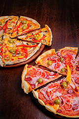 Image showing Pizza with tomato, salami, peppeeoni, olives and yellow hot pepper