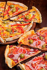 Image showing Pizza with tomato, salami, peppeeoni, olives and yellow hot pepper