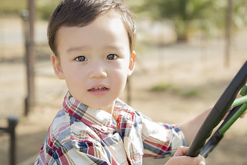 Image showing Mixed Race Young Boy Playing on Tractor