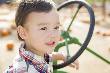 Image showing Mixed Race Young Boy Playing on Tractor