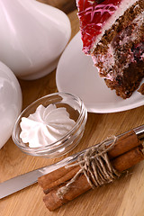 Image showing Piece of chocolate cake and white meringue on wooden background