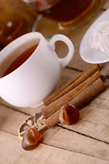 Image showing hot tea with lemon and cinnamon on wooden backgroubd