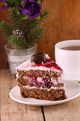 Image showing pieces of cake on wooden background with flowers and tea cup