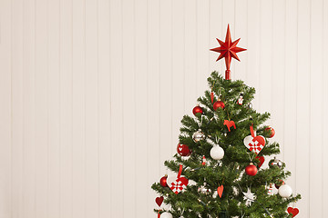 Image showing Christmas tree against a wooden wall