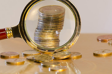Image showing A stack of coins under a magnifying glass