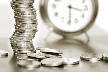 Image showing A stack of coins and alarm clock