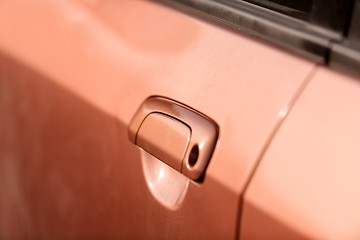 Image showing Handle of an orange car closeup