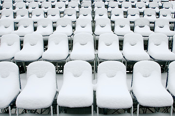 Image showing White stadium chairs covered in snow