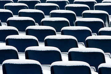 Image showing Blue plastic chairs covered in snow