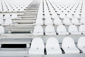 Image showing White plastic chairs in rows