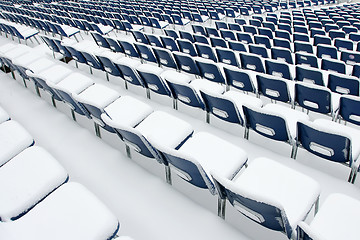 Image showing Empty plastic chairs covered in snow
