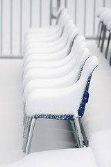 Image showing Chairs covered with snow