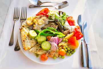 Image showing Meat, fish and various vegetable garnish on a plate.