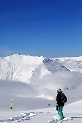 Image showing Snowboarder on off-piste slope with new fallen snow at nice day