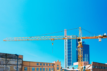 Image showing Construction Crane On Background Of New Modern Skyscraper And Ol