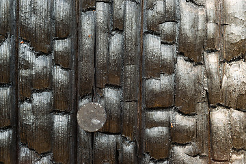 Image showing Burned Wood Fencepost Rusty Nail Charred Lumber