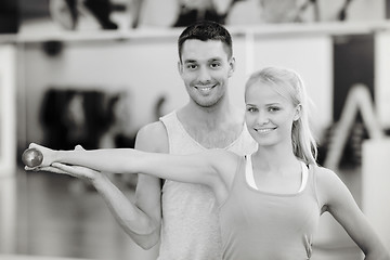 Image showing male trainer with woman working out with dumbbell