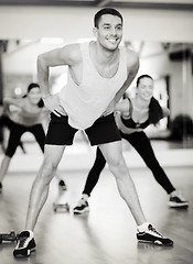 Image showing smiling male trainer working out in the gym