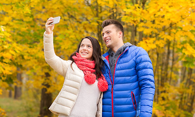 Image showing smiling couple hugging in autumn park