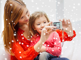 Image showing smiling mother and daughter with camera