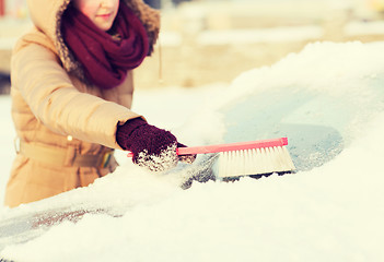Image showing woman cleaning snow from car back window