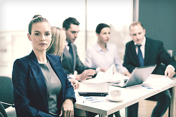 Image showing businesswoman in office with team on the back