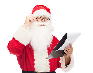 Image showing man in costume of santa claus with notepad