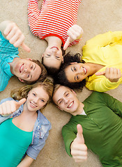 Image showing group of smiling people lying down on floor