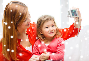 Image showing smiling mother and daughter with camera