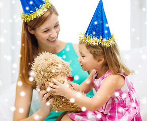 Image showing mother and daughter in party hats with toy