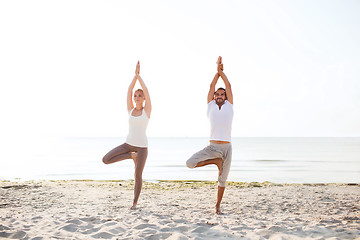 Image showing couple making yoga exercises outdoors