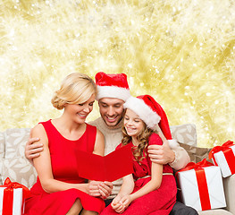 Image showing happy family in santa helper hats with gift boxes