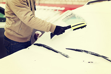 Image showing closeup of man cleaning snow from car