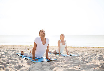 Image showing couple making yoga exercises outdoors