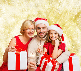 Image showing happy family in santa helper hats with gift boxes