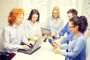 Image showing smiling team with laptop and table pc computers