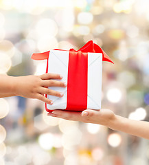 Image showing close up of child and mother hands with gift box