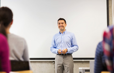 Image showing group of students and smiling teacher in classroom