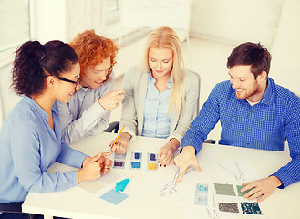 Image showing smiling creative team looking at sketch