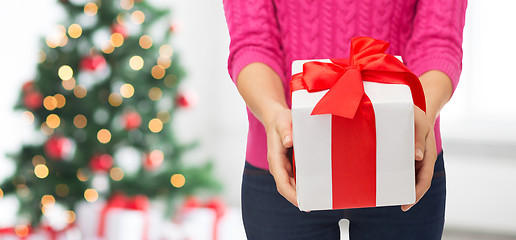 Image showing close up of woman in pink sweater holding gift box