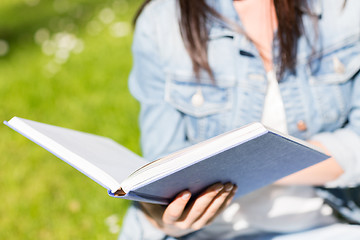 Image showing close up of young girl with book in park