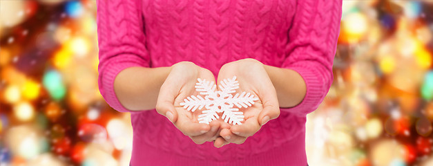 Image showing close up of woman in sweater holding snowflake