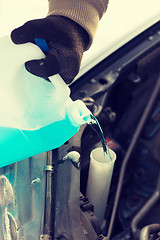 Image showing closeup of man pouring antifreeze into water tank