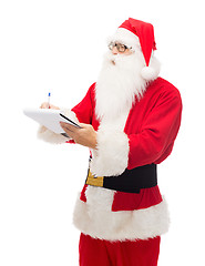 Image showing man in costume of santa claus with notepad