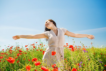 Image showing smiling young woman on poppy field