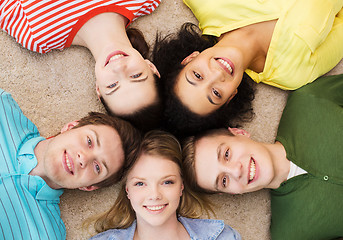 Image showing group of smiling people lying down on floor