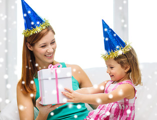 Image showing mother and daughter in party hats with gift box