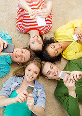 Image showing group of smiling people lying down on floor