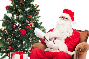 Image showing man in costume of santa claus with notepad